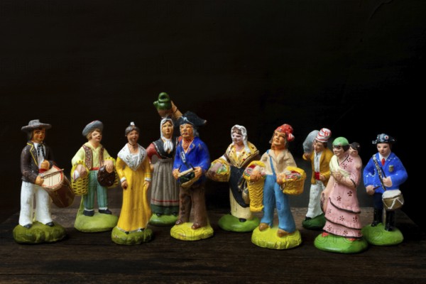 Colorful Provençal terracotta figurines represent traditional characters from rural life. Each figure is uniquely crafted, depicting musicians, farmers, and market sellers in detailed attire