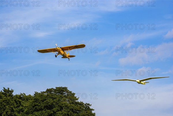 A Piper PA-18 Super Cub tows a glider during an air show at the Rossfeld in Metzingen-Glems, Baden-Württemberg, Germany, for editorial use only