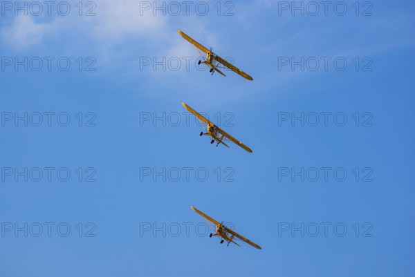 Three Piper PA-18 Super Cub aeroplanes of the Bravo Lima Formation flying in formation during an air show at the Rossfeld in Metzingen-Glems, Baden-Württemberg, Germany, for editorial use only