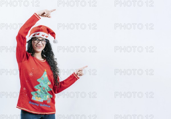 Happy young woman in Christmas sweater recommending and pointing aside. Smiling girl in Christmas sweater pointing to the side, isolated