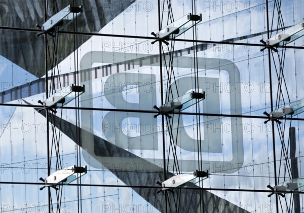 Cube Berlin seen through the glass facade of the main railway station with the mirror-inverted DB logo, Washingtonplatz, Berlin, Germany