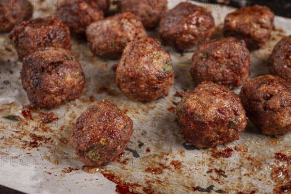 Homemade meatballs cooked to perfection on a baking tray with seasoning and herbs, Swedish meatballs