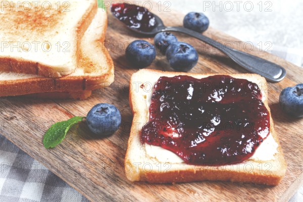 Toast with blueberry jam, on a wooden chopping board, breakfast, homemade, no people