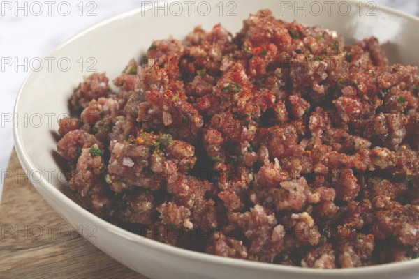 Raw minced meat, marinated with spices and herbs, in a bowl, minced meat with spices, top view, homemade, no people