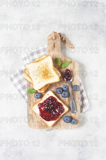 Toast with blueberry jam, on a wooden chopping board, breakfast, homemade, no people