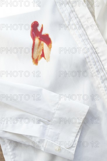 White shirt stained with ketchup, no people, close-up, selective focus