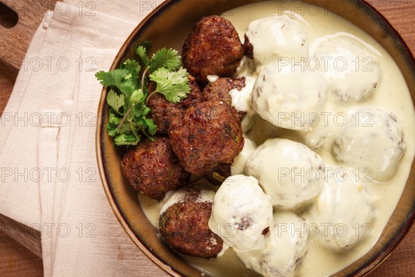Swedish meatballs in cream sauce, plate on a wooden table, homemade, no people