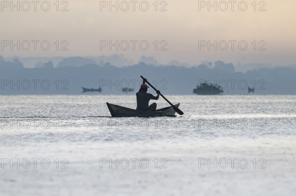 Fisherman in a rowing boat, silhouette, morning mood, Mabamba Swamp, Lake Victoria, Uganda