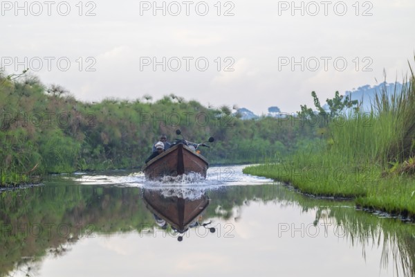 Transport boat, ferry boat with passengers and motorbike between Seeta and Bussi in the Mabamba Swamp, Lake Victoria, Uganda