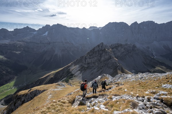 Group of mountaineers descending from the Gamsjoch, in autumn, mountain panorama with Spritzkarspitze and summit of the Hinterautal-Vomper chain, Rißtal in the Eng, Karwendel, Tyrol, Austria