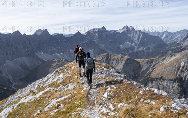 Mountain panorama with picturesque mountain landscape, group of mountaineers descending from the Gamsjoch, in autumn, behind mountain ridge of the Hinterautal-Vomper chain, Rißtal in the Eng, Karwendel, Tyrol, Austria