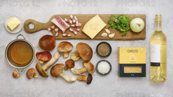 Fresh ingredients for a tasty risoni dish with porcini mushrooms are beautifully arranged on a countertop. This cozy kitchen scene showcases the vibrant colors and textures of each item
