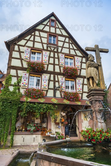 Emperor Constantin fountain in front of a half-timbered house in Kaysersberg