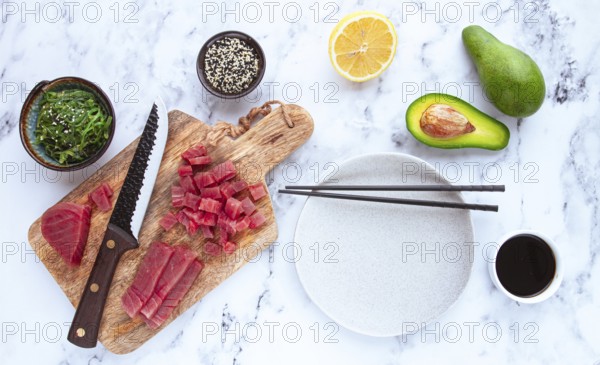 Cooking fresh tuna with ingredients on a marble countertop, ingredients for making sushi and tuna tartare
