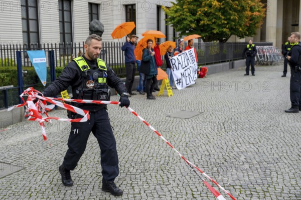 The New Generation symbolically organises a house search at the Family Business and Politics Foundation, a police officer removes the activists' cordon. Berlin, 10.10.2025