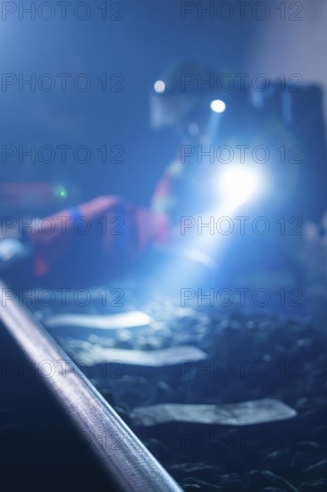 Blur of a person with a torch working on rails in the dark, fire drill in the new construction tunnel of the Hermann Hesse railway, Ostelsheim, district of Calw, Germany
