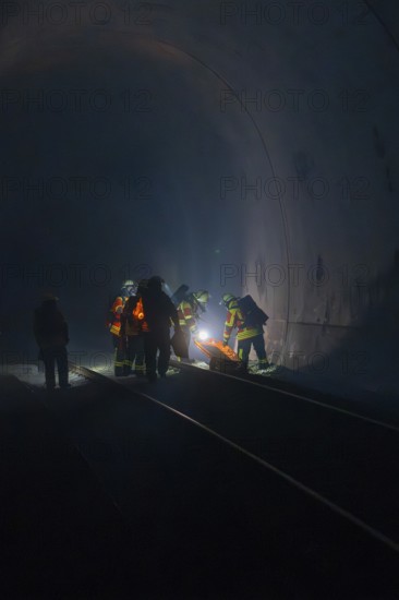 Group of firefighters in the tunnel, illuminated by a light source, fire drill in the new tunnel of the Hermann Hesse railway, Ostelsheim, district of Calw, Germany