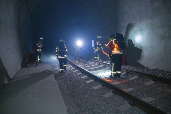 Firefighters working in the tunnel in the dark, accompanied by light sources, firefighting exercise in the new tunnel of the Hermann Hesse railway, Ostelsheim, district of Calw, Germany