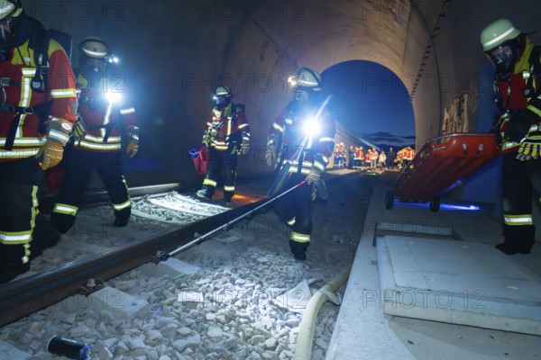 Firefighters in a tunnel at night, strong light illuminates the scene, firefighting exercise in the new tunnel of the Hermann Hesse railway, Ostelsheim, district of Calw, Germany