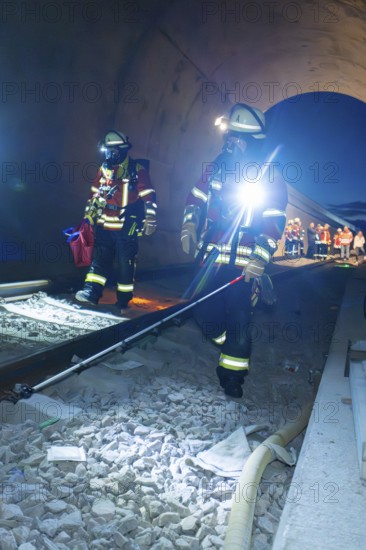 Firefighters during a rescue operation on rails in a tunnel, firefighting exercise in the new construction tunnel of the Hermann Hesse railway, Ostelsheim, Calw district, Germany