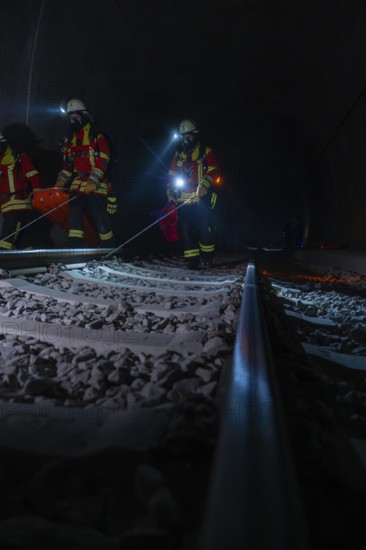 Rescue workers in the tunnel on railway tracks in the dark with blue lights, fire brigade exercise in the new tunnel of the Hermann Hessebahn, Ostelsheim, Calw district, Germany