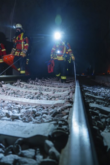 Firefighters on rails, the surroundings illuminated by emergency lighting, firefighting exercise in the new construction tunnel of the Hermann Hesse railway, Ostelsheim, district of Calw, Germany