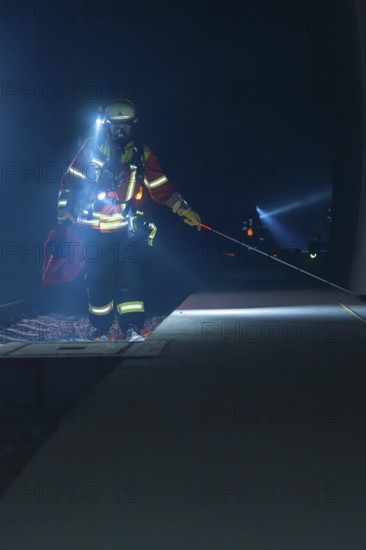 Fireman with glow stick on a railway track, illuminated surroundings, fire drill in the new construction tunnel of the Hermann Hesse railway, Ostelsheim, district of Calw, Germany
