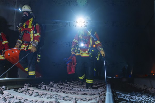 Two firefighters on tracks with headlamps at night, fire drill in the new construction tunnel of the Hermann Hesse railway, Ostelsheim, district of Calw, Germany