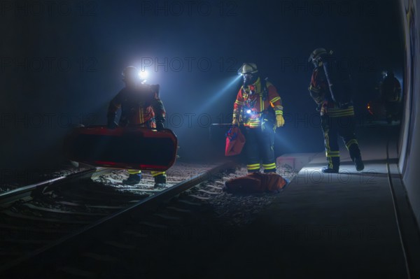 Group of firefighters during a night-time operation on the tracks, firefighting exercise in the new construction tunnel of the Hermann Hesse railway, Ostelsheim, Calw district, Germany