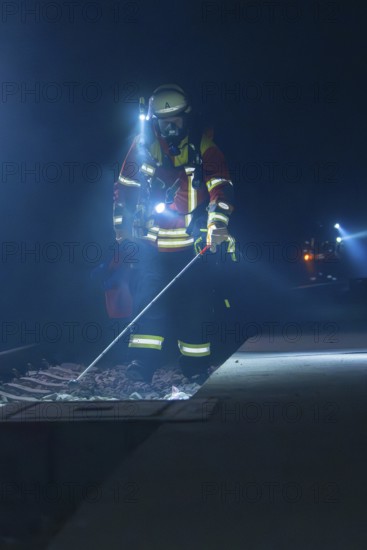 Firefighter examining railway track with lantern in a dark environment, firefighting exercise in the new construction tunnel of the Hermann Hessebahn, Ostelsheim, Calw district, Germany