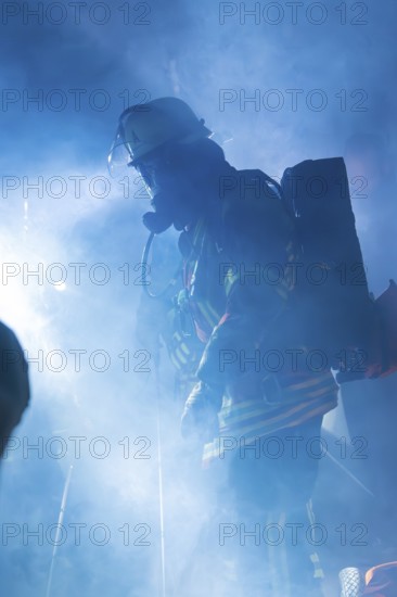 Firefighter in smoke with breathing apparatus and helmet, blue light surrounding him, fire drill in the new tunnel of the Hermann Hesse railway, Ostelsheim, district of Calw, Germany