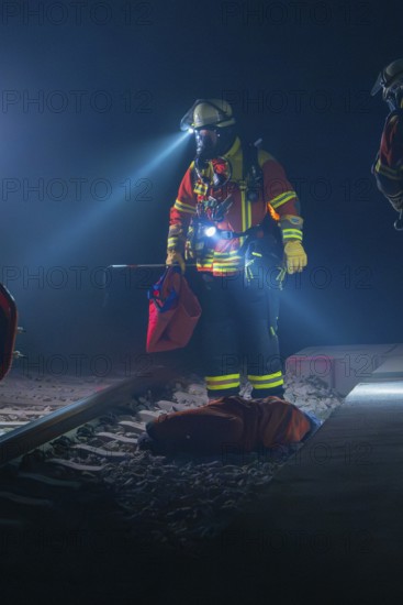 Fireman illuminates the tracks with a torch, nocturnal atmosphere, fire drill in the new tunnel of the Hermann Hesse railway, Ostelsheim, district of Calw, Germany