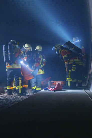 Firefighters working on the tracks at night, illuminated by helmet lamps, firefighting exercise in the new tunnel of the Hermann Hesse railway, Ostelsheim, Calw district, Germany