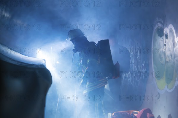Firefighters with breathing apparatus shrouded in fog, illuminated by bluish light, firefighting exercise in the new tunnel of the Hermann Hesse railway, Ostelsheim, Calw district, Germany