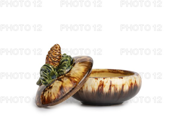 Ceramic jar with pine cones on the lid, white background