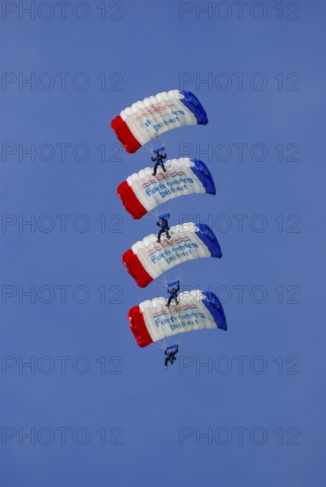 Parachutists during an aerial acrobatic demonstration as part of an air show on the Rossfeld in Metzingen-Glems, Baden-Württemberg, Germany, for editorial use only