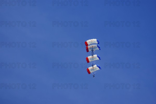 Parachutists during an aerial acrobatic demonstration as part of an air show on the Rossfeld in Metzingen-Glems, Baden-Württemberg, Germany, for editorial use only
