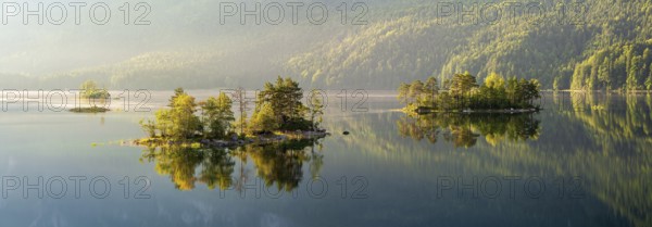 Morning atmosphere at the Eibsee lake, small islands in the first light are reflected in the water, Grainau near Garmisch-Partenkirchen, Upper Bavaria, Bavaria, Germany