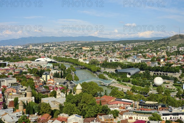 Beautiful view of Tbilisi showing the river, bridges, and green parks on a sunny day