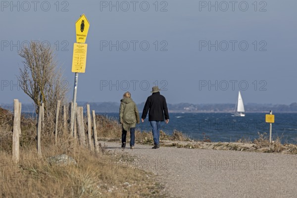Walkers going into the nature reserve, path, Baltic Sea, sailing boat, Geltinger Birk, Nieby, Schleswig-Holstein, Germany