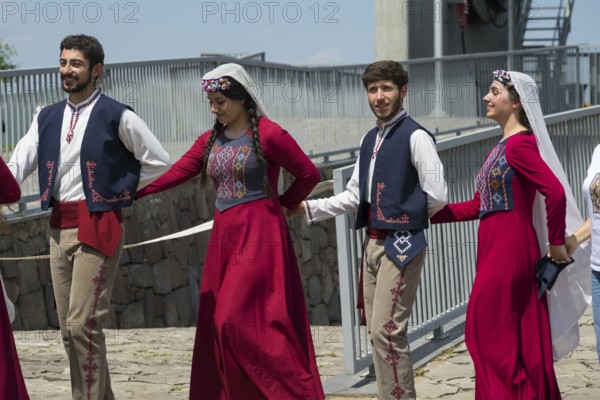 Group in colourful traditional costume holding hands while dancing, folklore, Tatev, Tatev, Syunik province, Syunik, Armenia