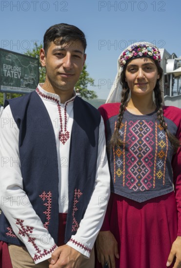 Close-up of a couple in traditional traditional costume in front of a sign, folklore, Tatev, Tatev, Syunik province, Syunik, Armenia