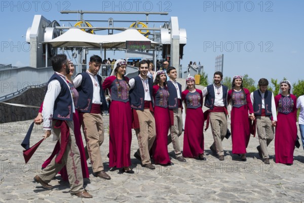 Group performing traditional dance on paved area in sunny weather, folklore, Tatev, Tatev, Syunik province, Syunik, Armenia