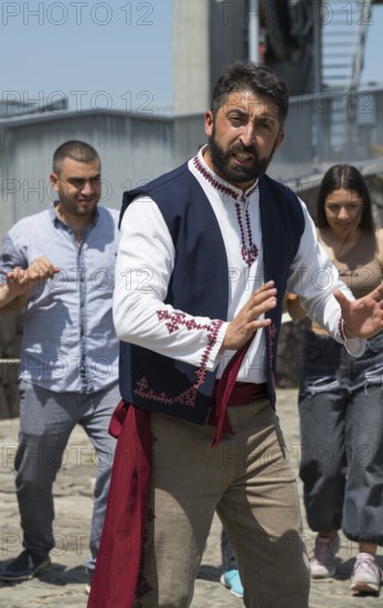 Man in folkloric clothes dancing, accompanied by other people, folklore, Tatev, Tatev, Syunik province, Syunik, Armenia