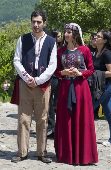 Two people in traditional clothes standing on a square in sunny weather, folklore, Tatev, Tatev, Syunik province, Syunik, Armenia