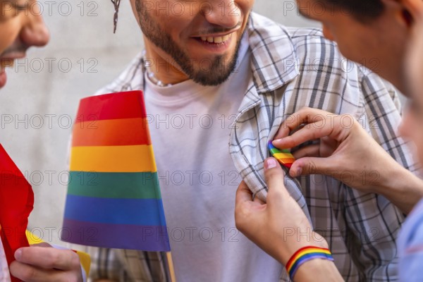 Happy man smiles as someone pins a rainbow flag badge to his plaid shirt, celebrating lgbtq pride, support, diversity and unity at an outdoor event or parade