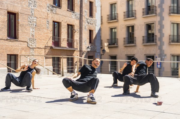 Group of diverse urban dancers concentrating on a synchronized performance, moving in dynamic poses on a sunny city square while expressing energy and passion for street art