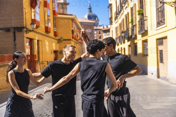 Group of young friends enjoying an urban contemporary dance performance, expressing joy and freedom while moving together on a sunny street in madrid, spain