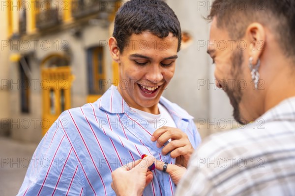 Gay man happily receiving a pride flag pin from his partner on a city street, joyful embrace and laughter celebrating lgbtq plus identity, love, support and urban togetherness
