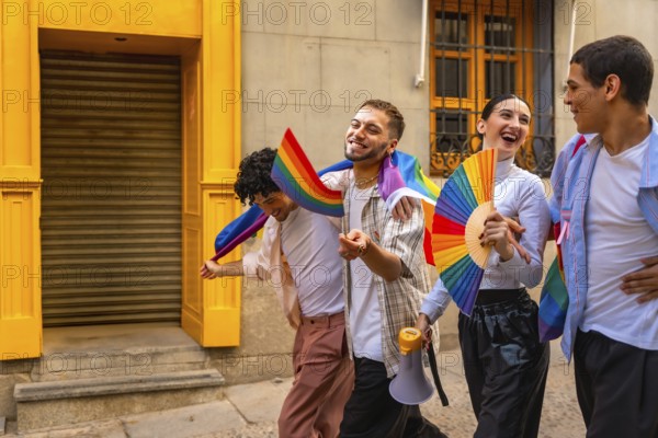 Group of diverse young happy friends walking on a street, celebrating pride day, holding rainbow flags, a fan, and a megaphone, showing unity, freedom, and acceptance for their community